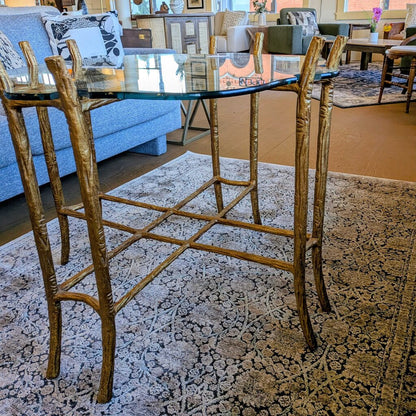 Glass dining table with wooden chairs on a patterned rug in a living room setting.