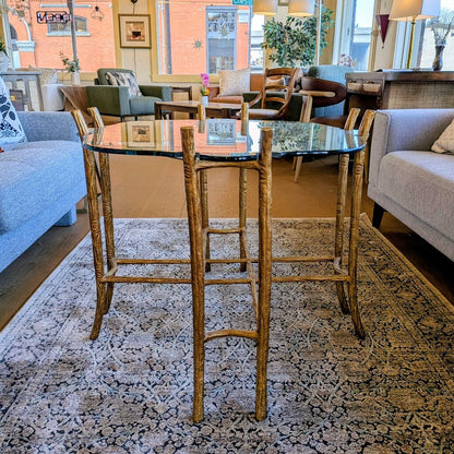 High-top dining table with wooden chairs in a living room setting.