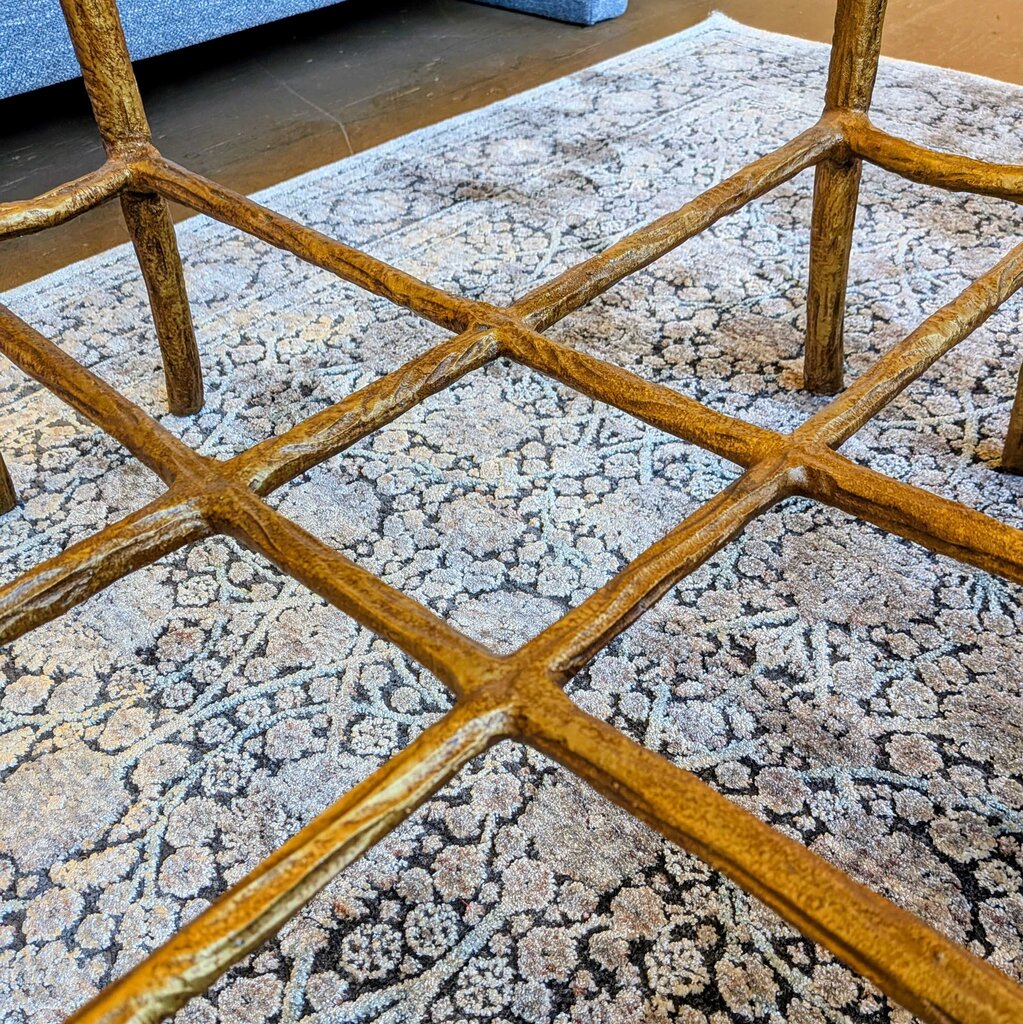 Close-up of a textured rug with geometric pattern and wooden chair legs.
