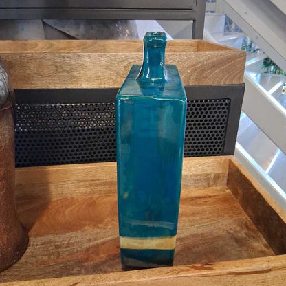 Blue glass bottle on a wooden surface with a blurred background
