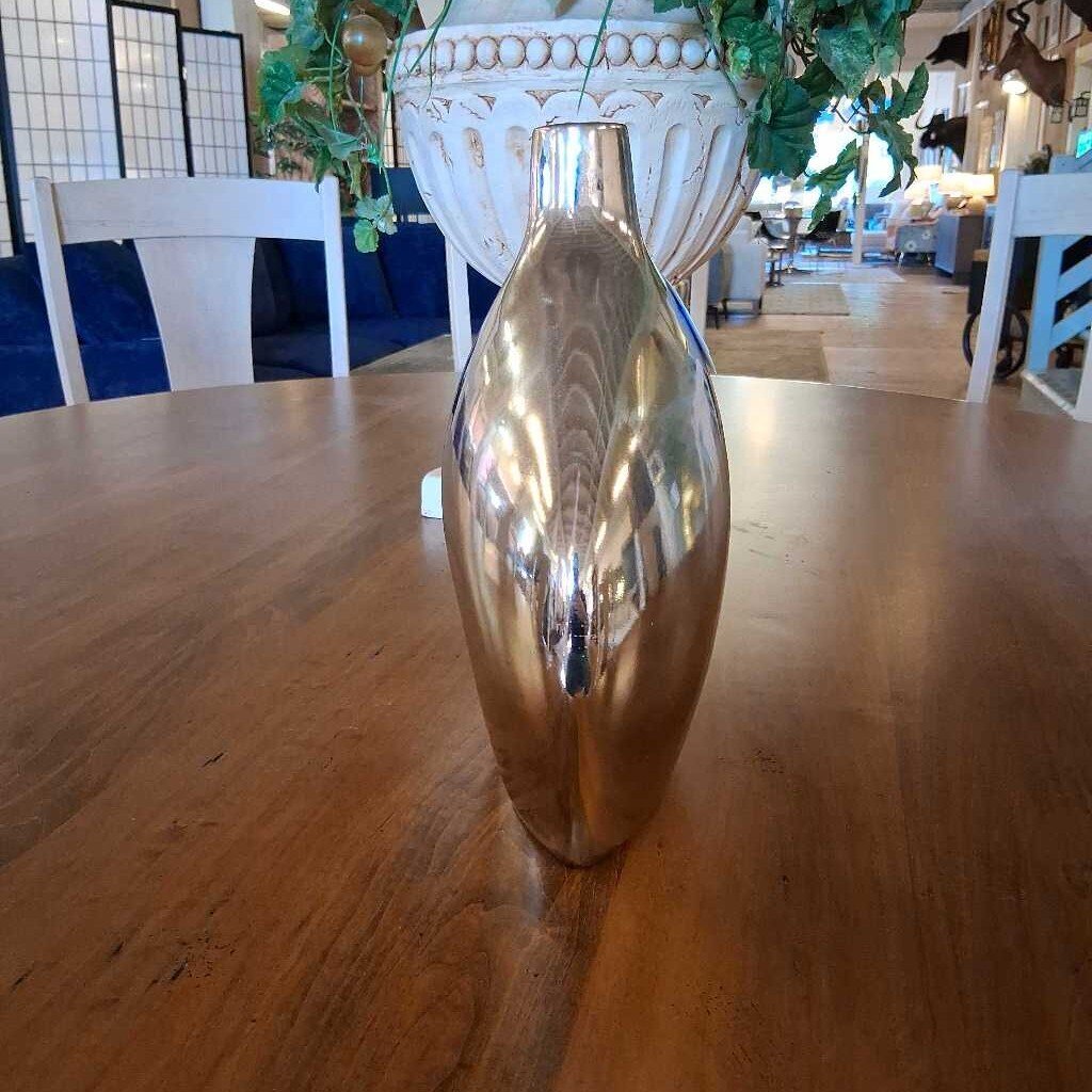 Silver vase on a wooden table with a blurred indoor setting