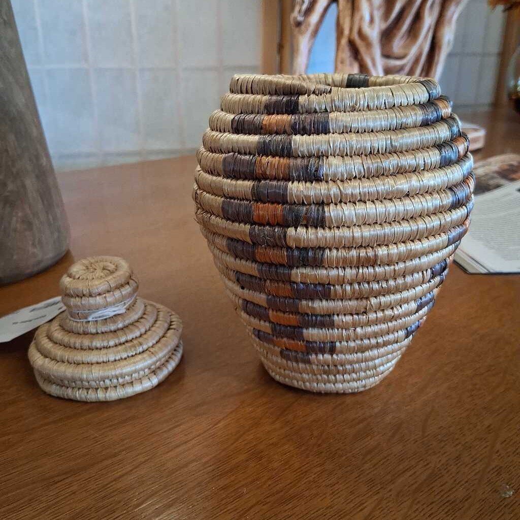 Woven basket with a lid on a wooden surface