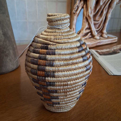 Woven vase on a wooden surface with a blurred background
