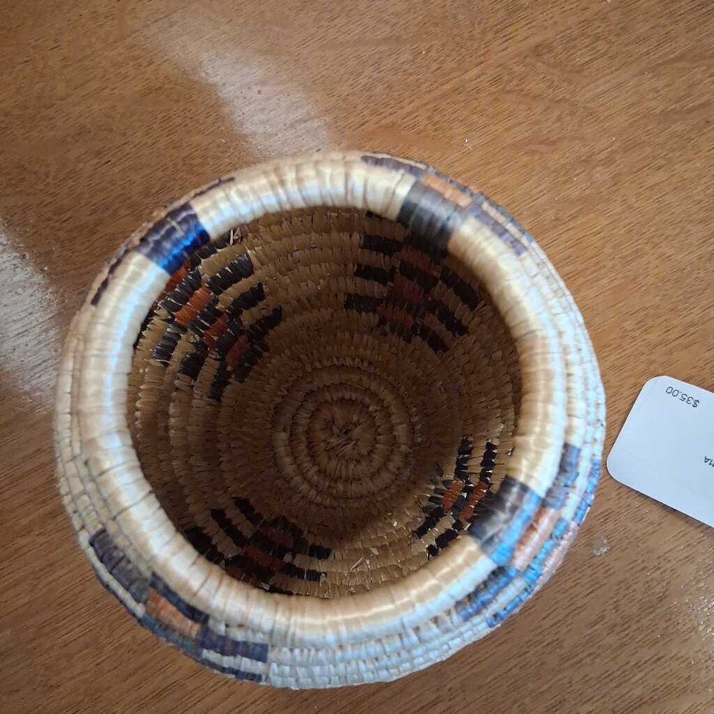 Woven basket with decorative patterns on a wooden surface