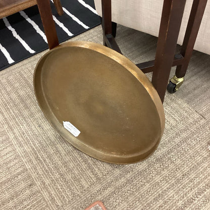 Brown oval tray on a carpeted floor with furniture in the background