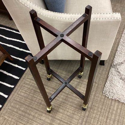 Wooden stand with X-shaped design on a carpeted floor
