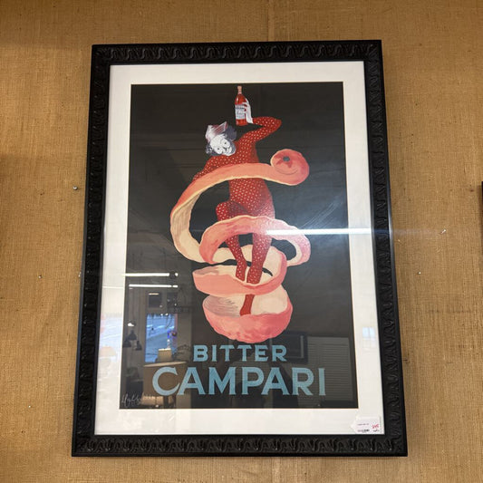 Framed poster of Bitter Campari with a red snake design on a wooden surface