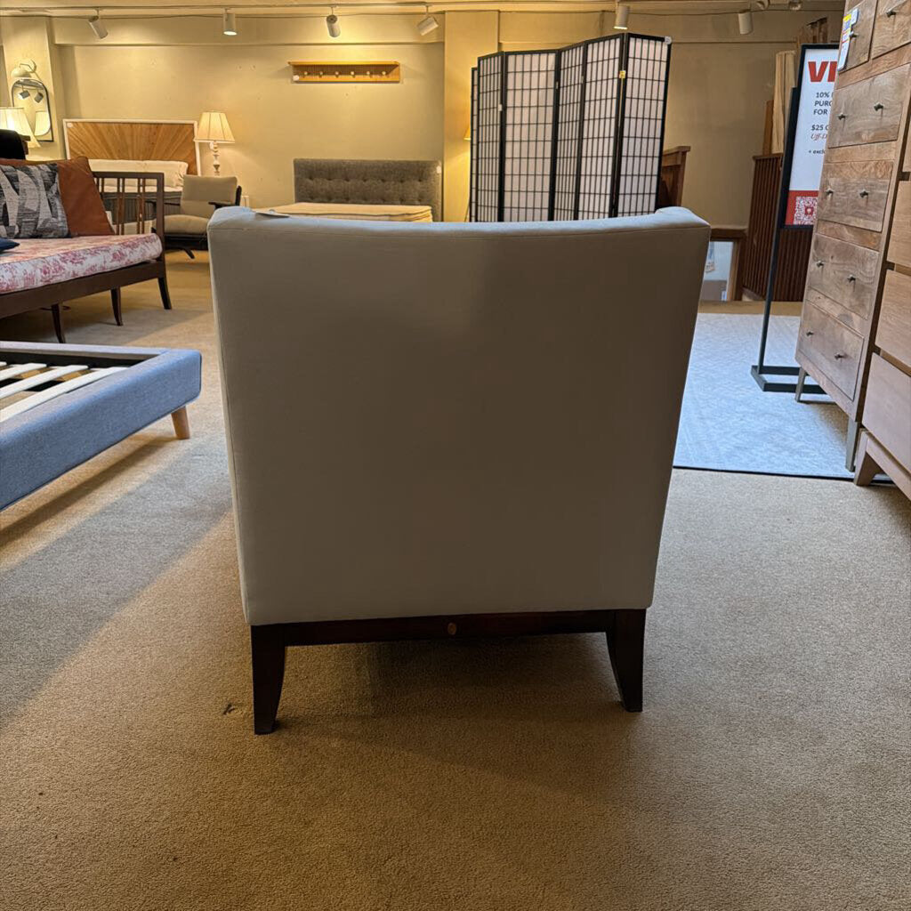 White armchair in a furniture store with other items in the background