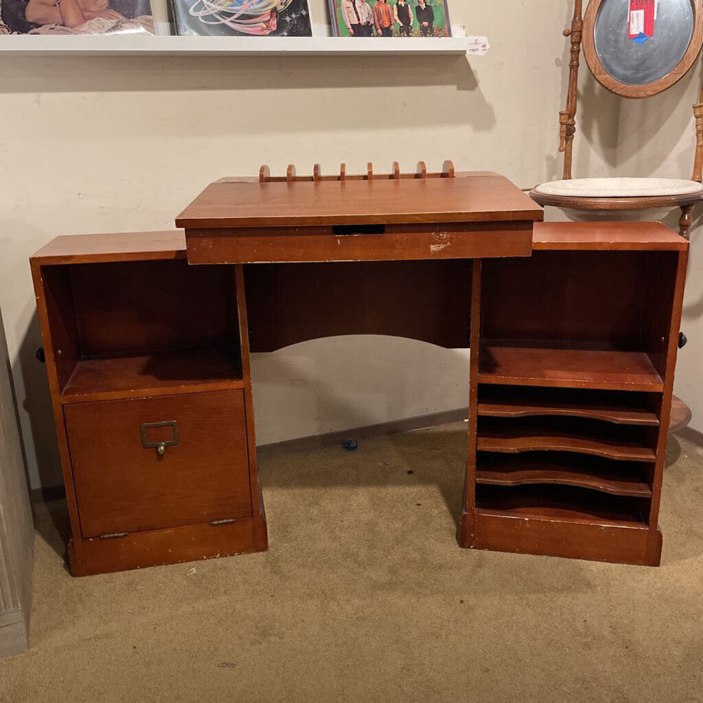 Wooden desk with shelves and a small table in a room setting.