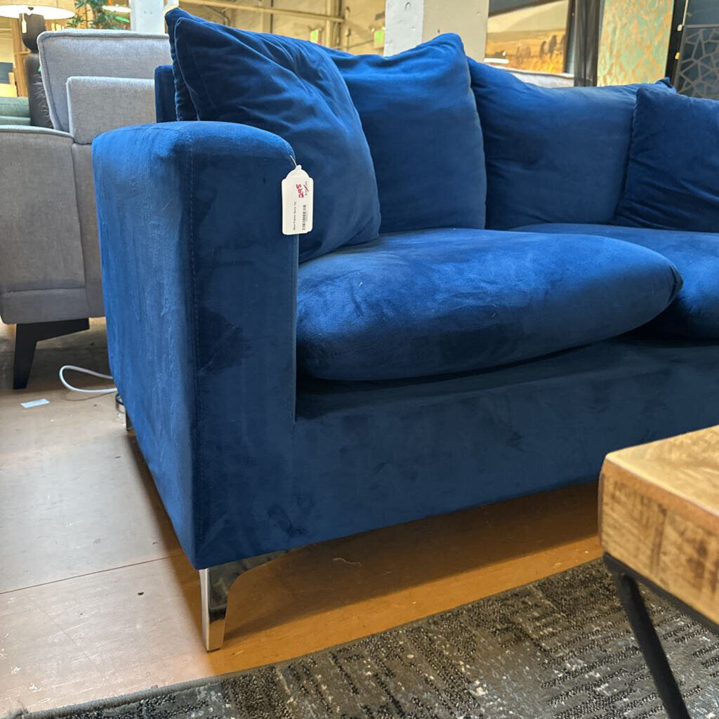 Blue sofa with a price tag in a store setting