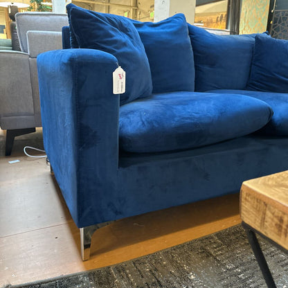 Blue sofa with a price tag in a store setting