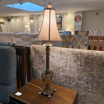 Decorative lamp on a table with a couch and chair in the background