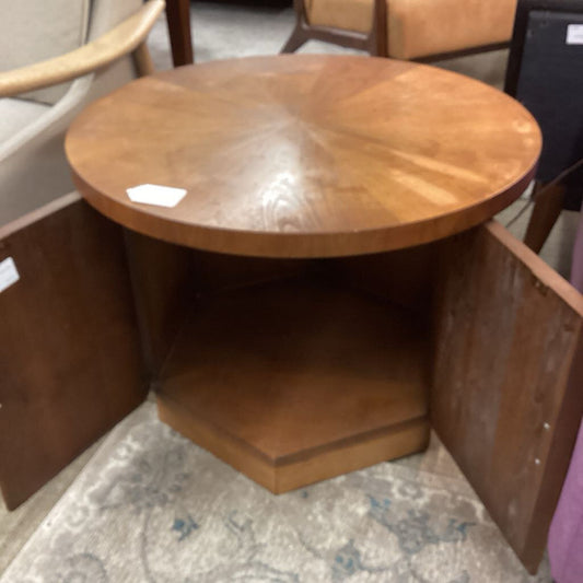 Wooden corner table with a round top in a room setting