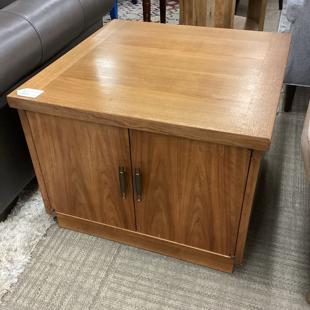 Wooden side table with two doors on a carpeted floor