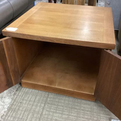 Wooden side table with a shelf on a carpeted floor