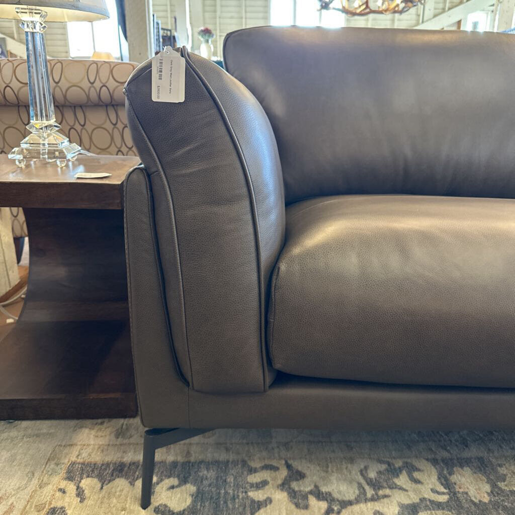 Gray sofa in a room with a table and lamp