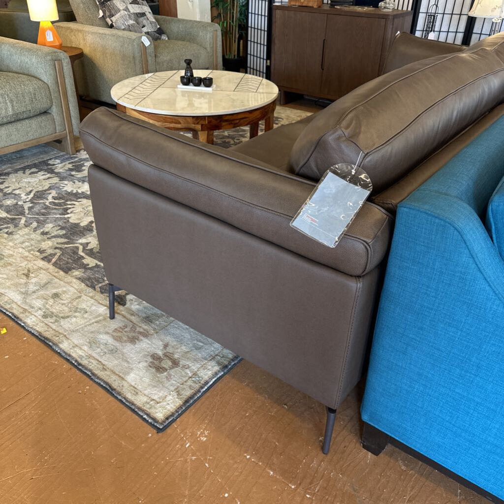 Brown leather sofa with a price tag in a showroom setting