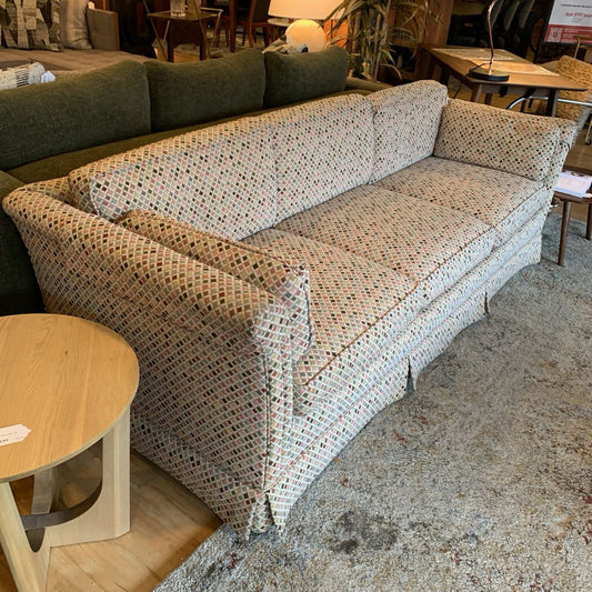 Patterned sofa in a room with furniture and decor