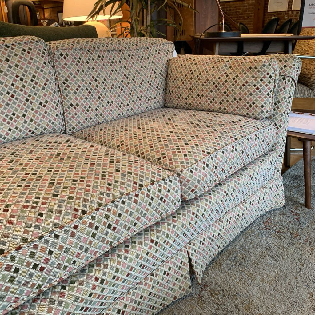 Patterned sofa in a room with chairs and a table.