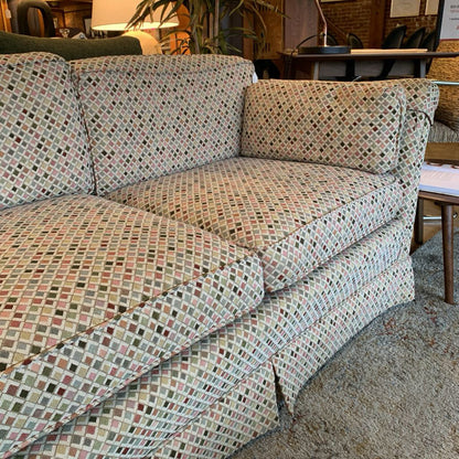 Patterned sofa in a room with chairs and a table.