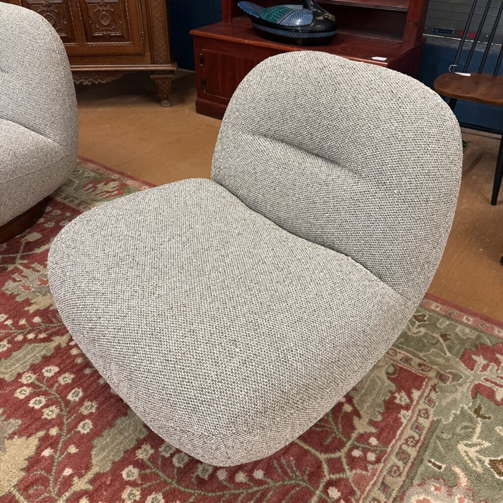 Gray textured chair on a patterned rug with wooden furniture in the background
