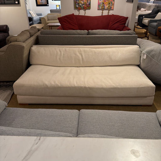 Sectional sofa with beige and gray cushions in a showroom setting.