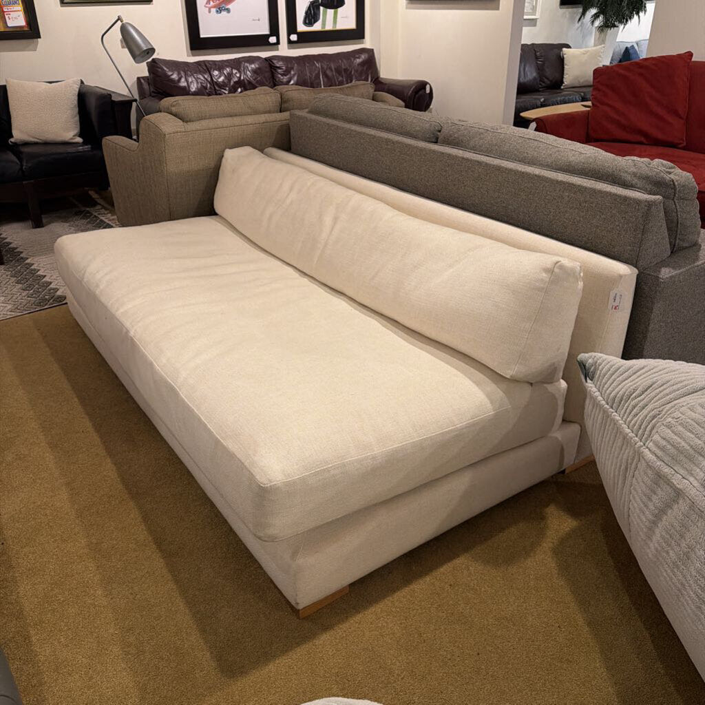Beige sectional sofa in a showroom with other furniture options.