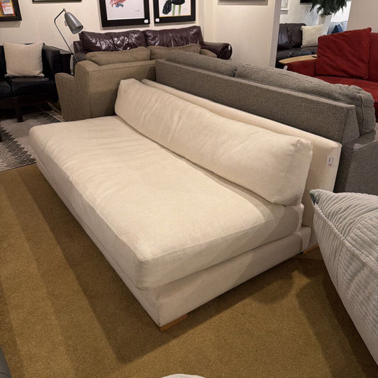 Beige sectional sofa in a showroom with other furniture options.