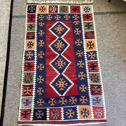 Decorative rug with geometric pattern on a gray floor
