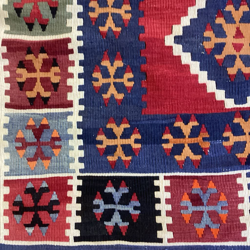 Close-up of a colorful patterned rug with geometric designs.