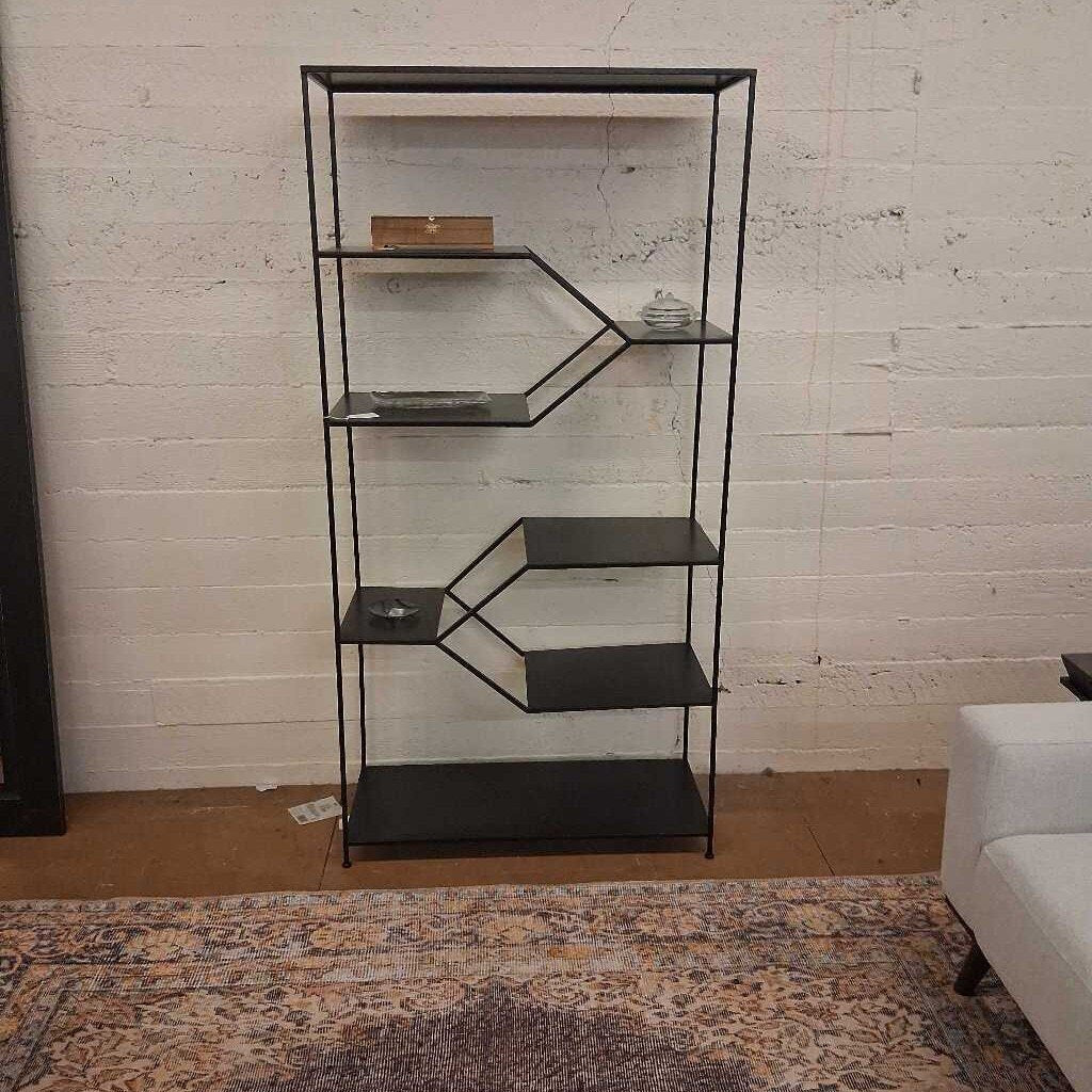 Black metal shelf against a white brick wall