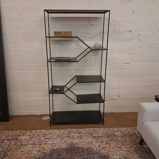 Black metal shelf against a white brick wall