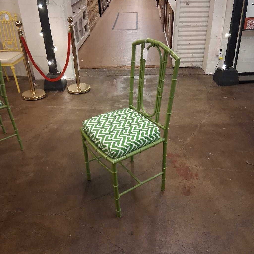 Green chair with a patterned cushion on a brown floor.