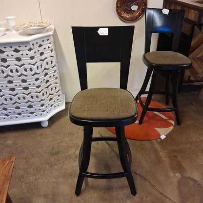 Bar stools with black frames and brown seats in a store setting.