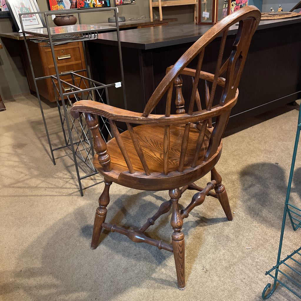 Wooden armchair in a store setting with furniture in the background