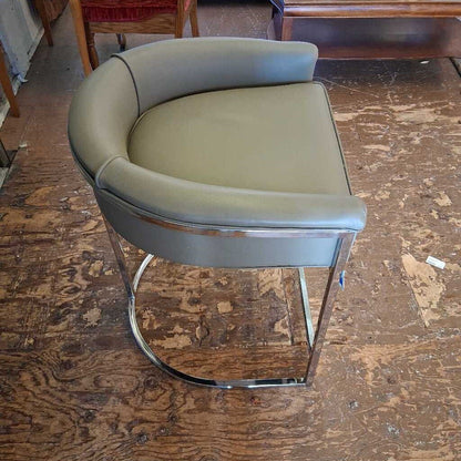 Modern green chair with chrome base on a wooden floor