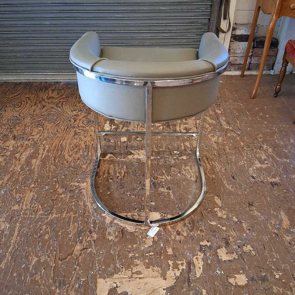 Bar stool with chrome base on a wooden floor