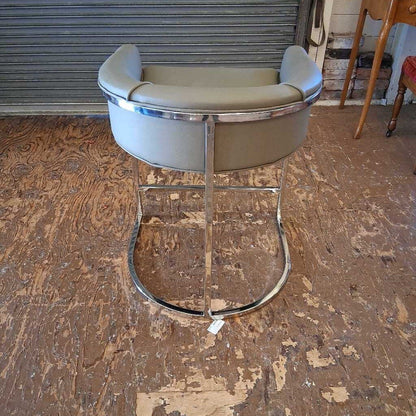 Bar stool with chrome base on a wooden floor