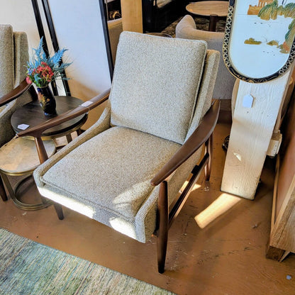 Chair with wooden frame and gray cushion in a room setting