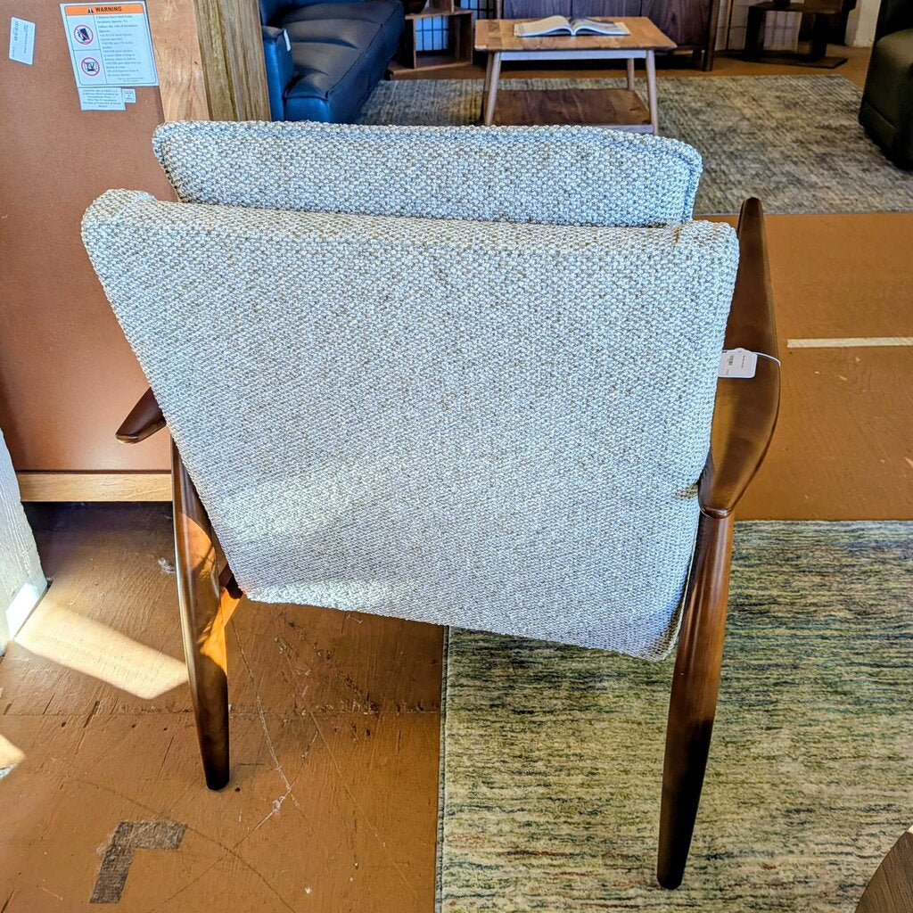 Two wooden chairs with blue fabric seats in a room setting.