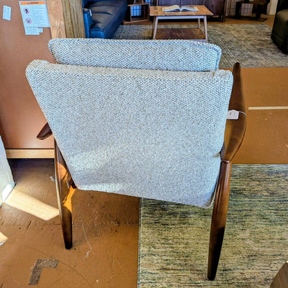 Two wooden chairs with blue fabric seats in a room setting.
