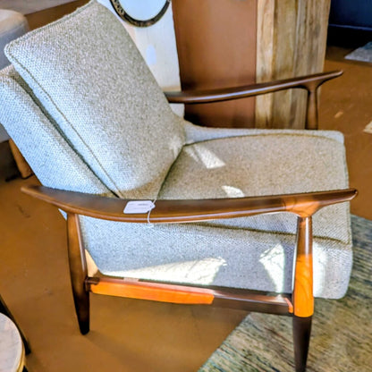 Chair with wooden armrests and orange accents in a room setting
