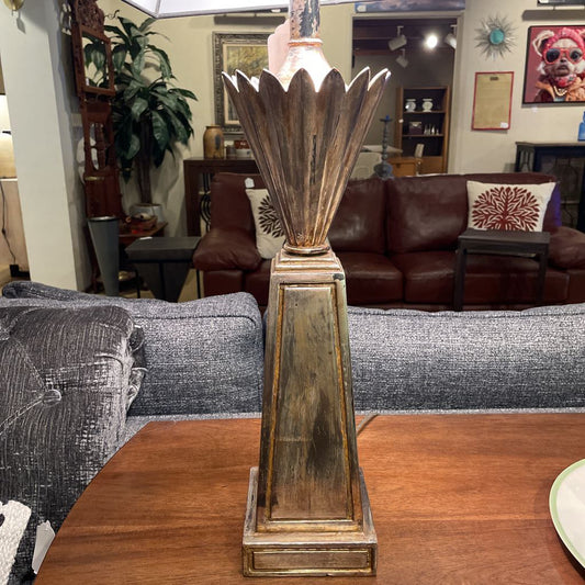 Decorative table lamp on a wooden table with a living room in the background
