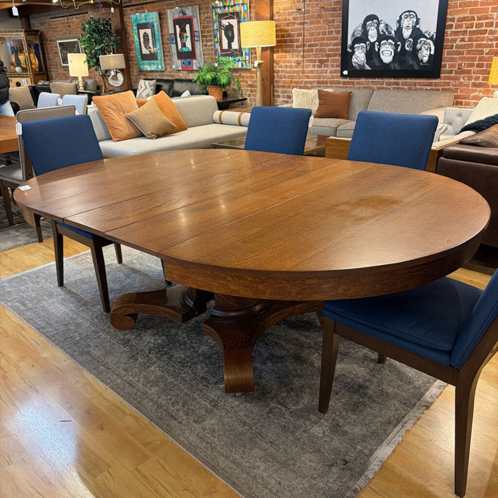 Wooden dining table with blue chairs in a living room setting