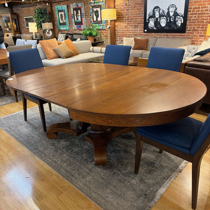 Wooden dining table with blue chairs in a living room setting
