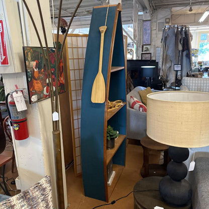 Blue bookshelf with a wooden paddle in a store setting