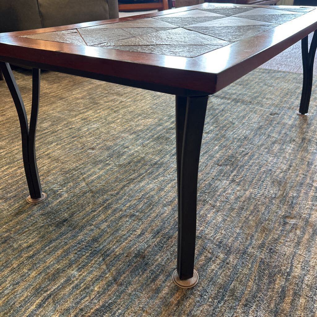 Wooden table with black legs on a patterned carpet