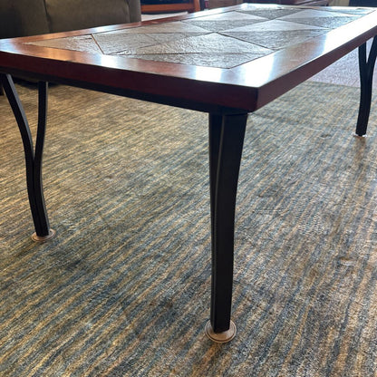 Wooden table with black legs on a patterned carpet