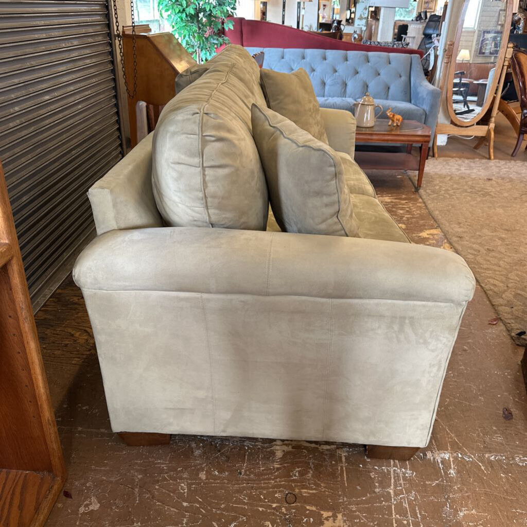 Beige sofa in a room with a mirror and other furniture.