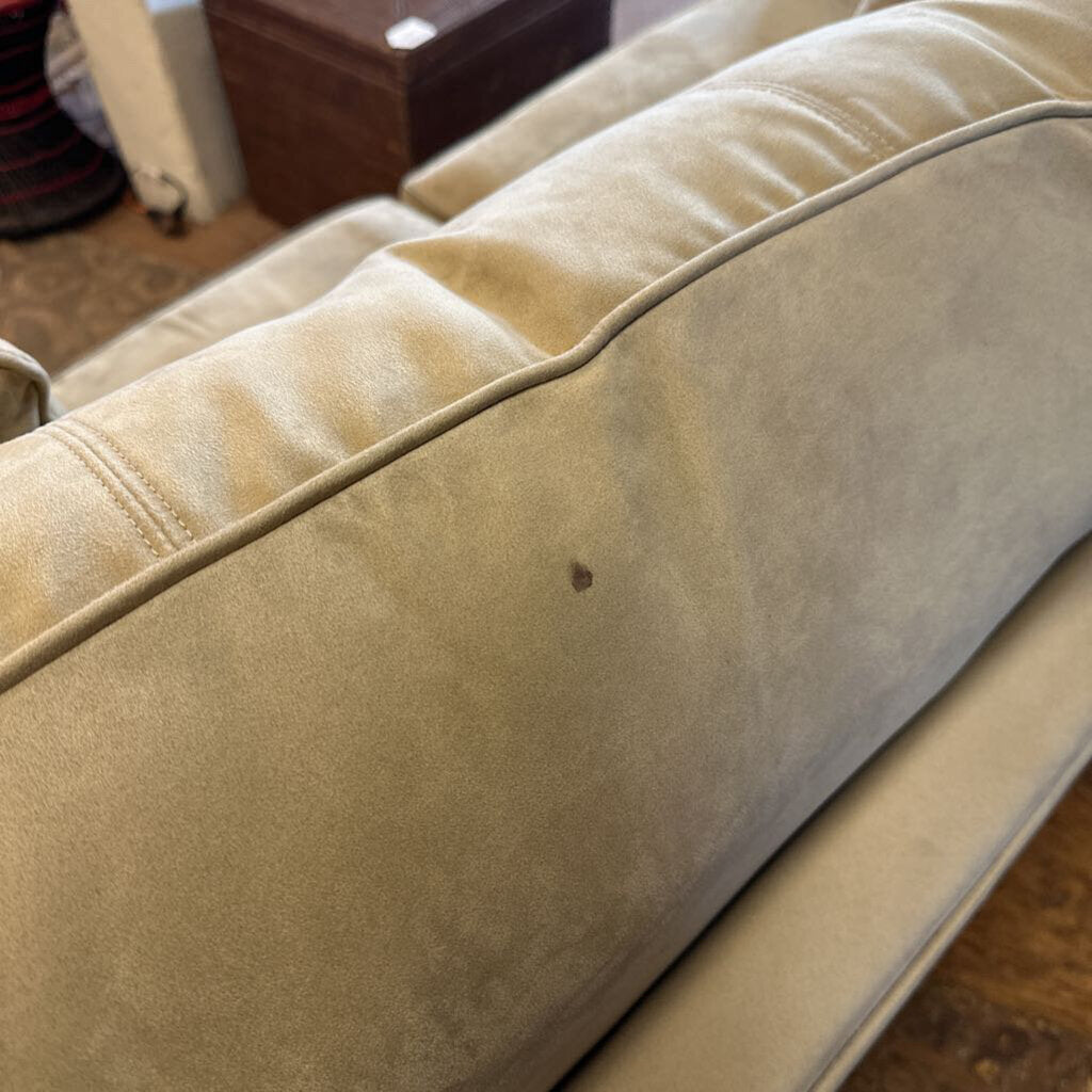 Beige sofa with a noticeable stain in a room setting